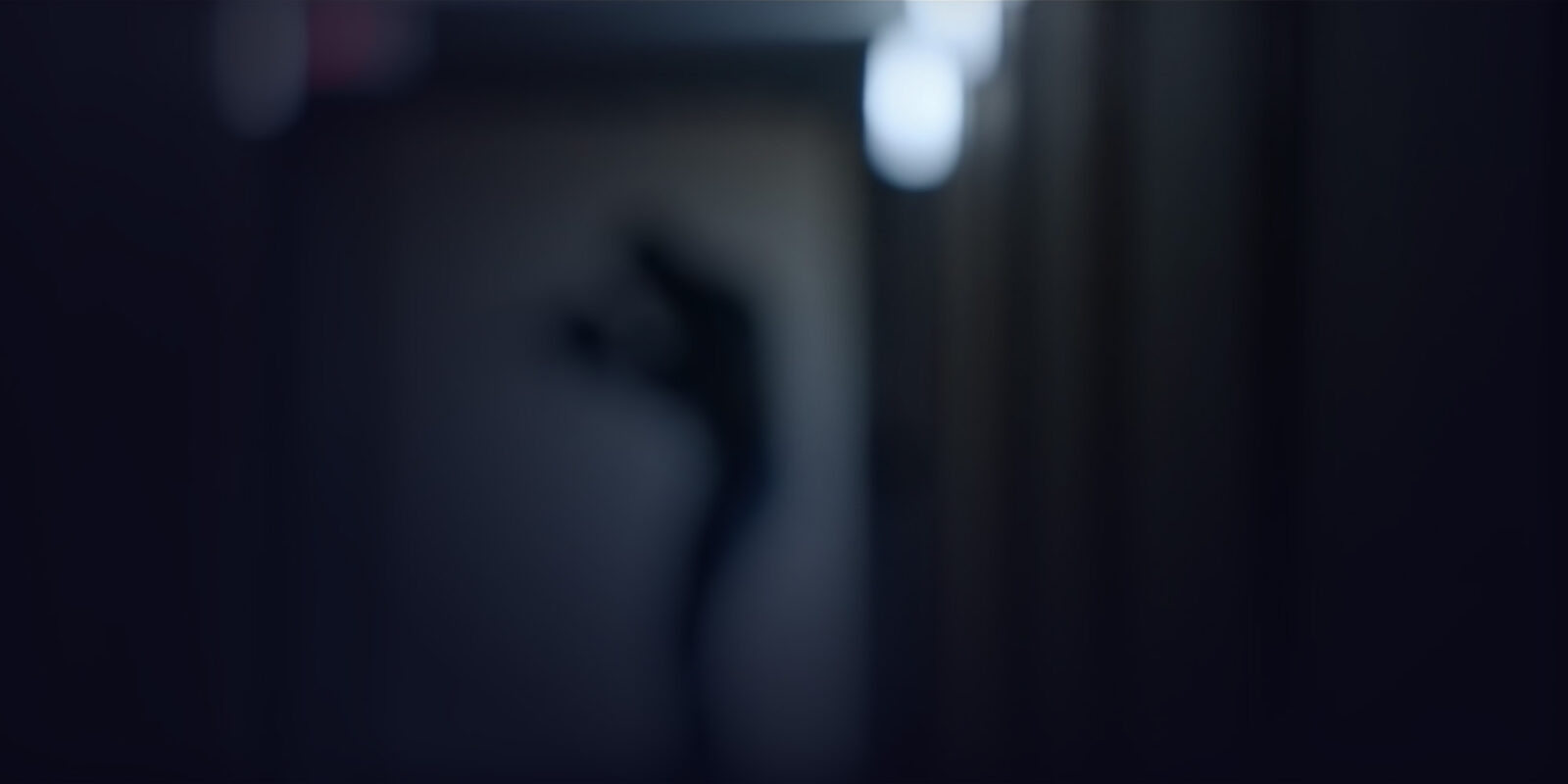 Blurry shadow of a person holding a knife