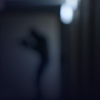 Blurry shadow of a person holding a knife