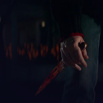 Close-up of a hand holding a bloody knife