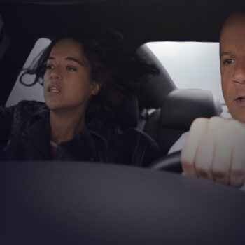 Close-up of a man holding the wheel of a car with a woman sitting next to him