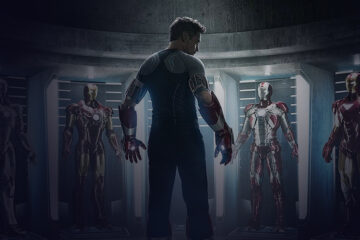 Character looking at the 5 Iron Man suits