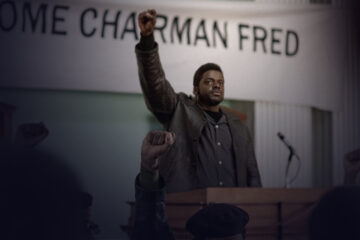 Man at a pulpit raising his fist