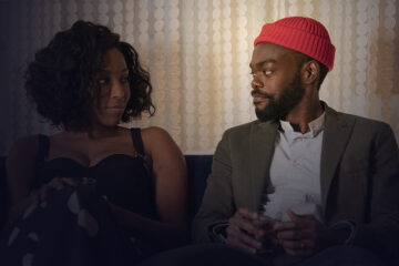 Woman and man sitting on a couch looking at each other
