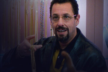 Close-up of a man holding a gold necklace