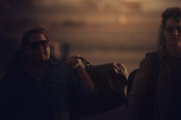 Two man carrying travel bags