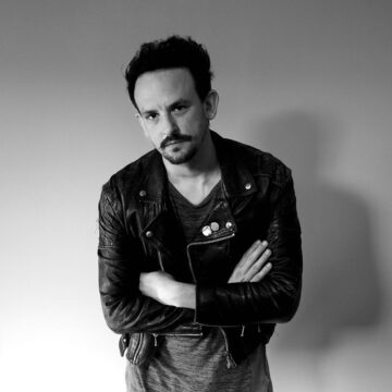 Medium shot of composer Kris Kovacs with his arms crossed