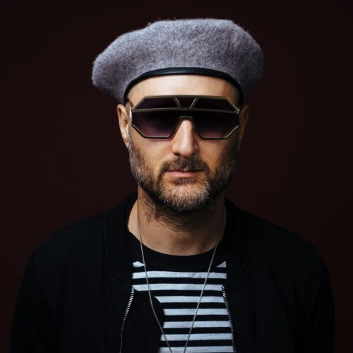 Close up of Sam I wearing big sunglasses and a beret