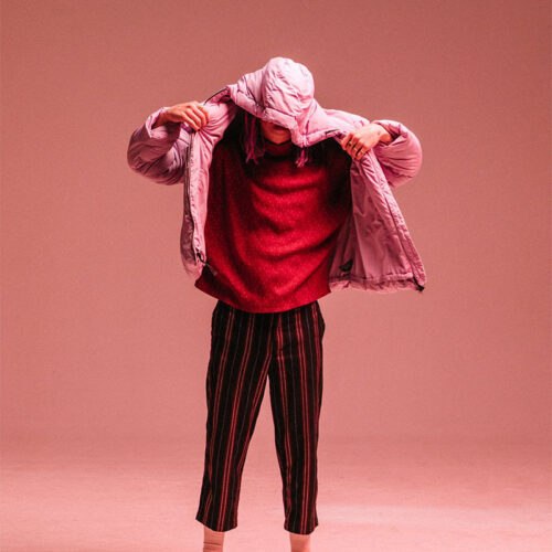 Artist Pink Laundry posing as if he was going to take off his coat