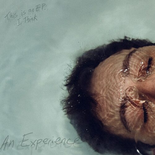 Close up of a face under water with their eyes closed.