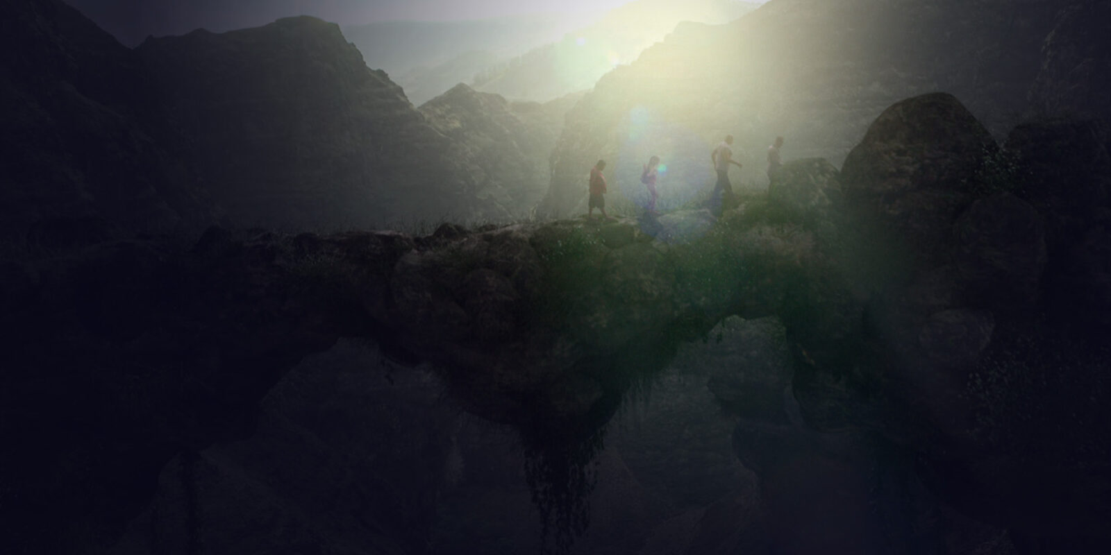 Four people crossing a stone bridge in the middle of the mountains