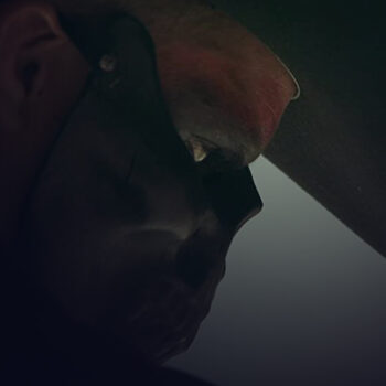 Close-up of a man's profile wearing a black skull mask up to his nose
