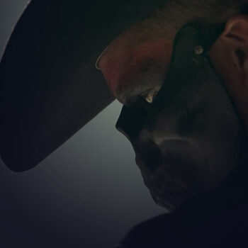 Close-up of a man's profile wearing a black skull mask up to his nose