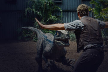 Man opening his arms and protecting himself from a dinosaur